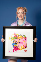 Model holding a framed Care Bears Cheer Bear print by MurWalls