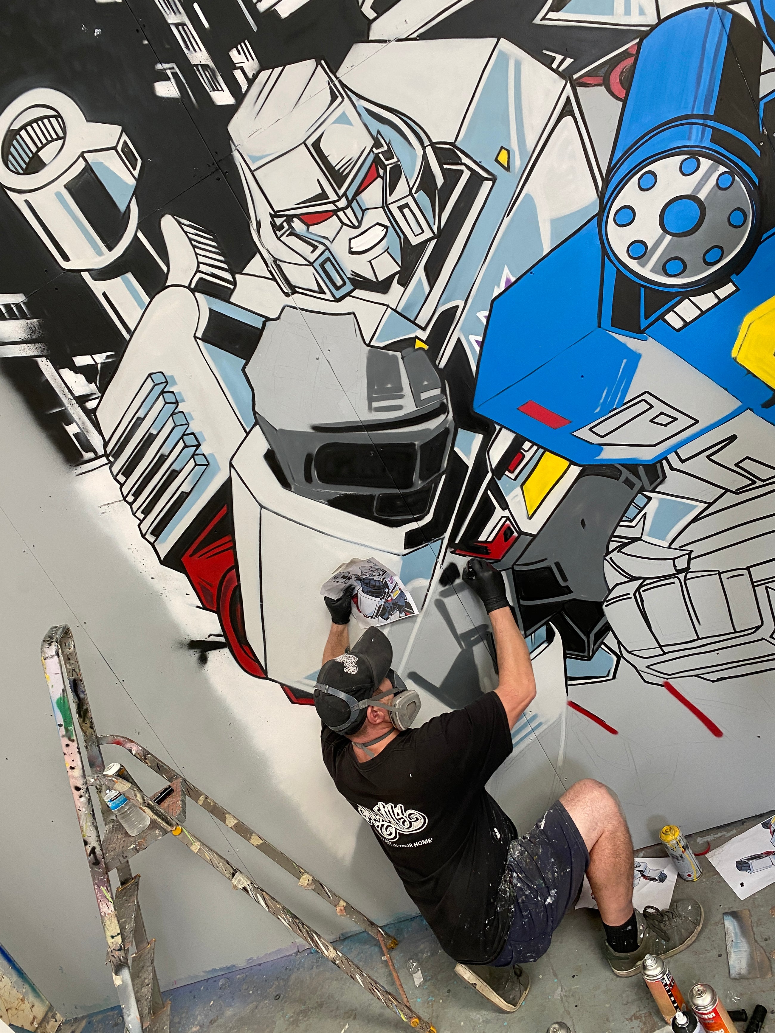 MurWalls artist working across the Transformers mural