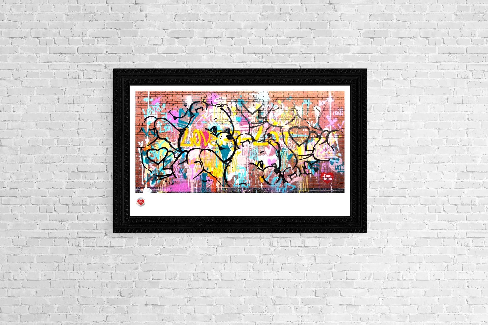 A framed Love-a-Lot Bear collector print displayed on a white brick wall