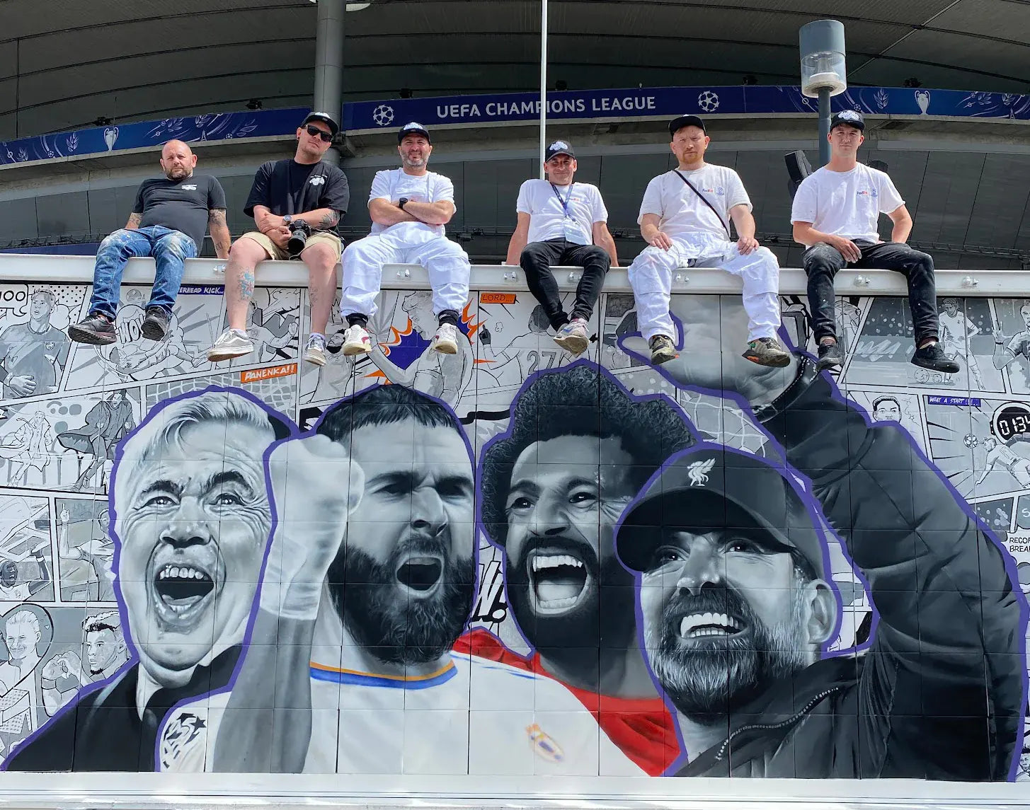 MurWalls artists sitting above their UEFA Champions League mural